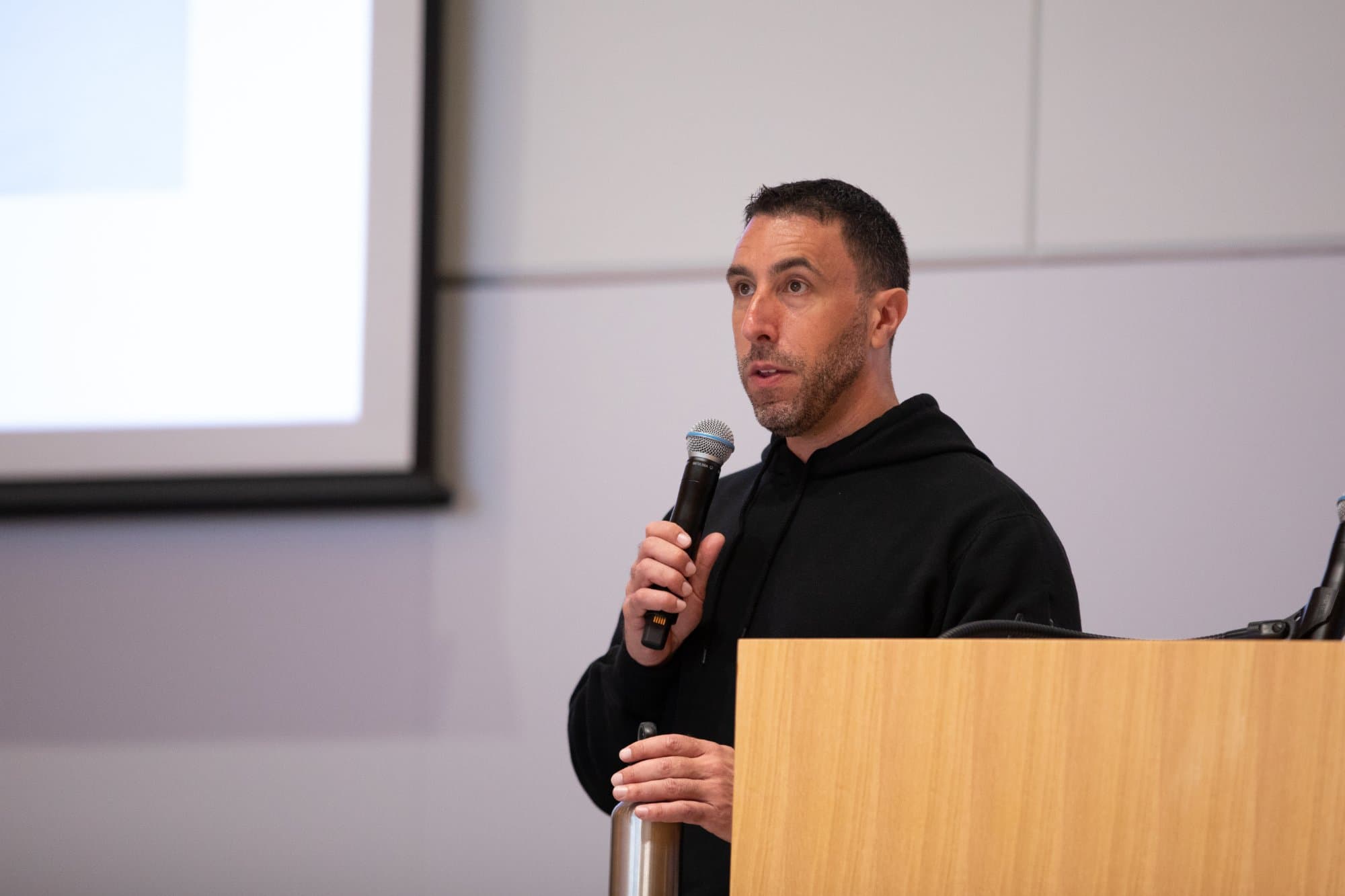 Ross leading an AI implementation workshop at a podium